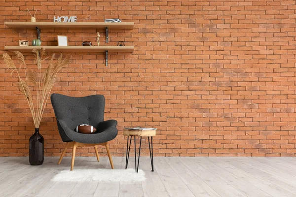 Odanın tuğla duvarının yanındaki koltukta rugby topu.