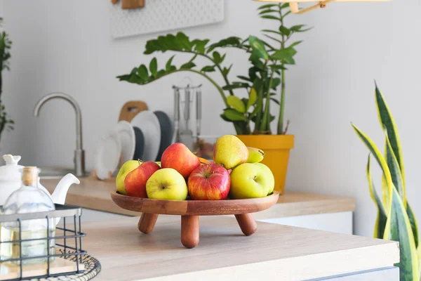 Mutfaktaki ahşap tepside taze meyveler var.