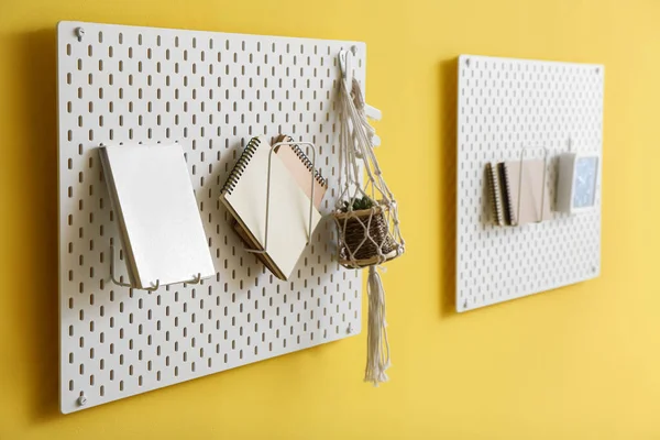 Renkli duvarda not defterleri ve çiçekli tahta panolar, yakın plan.