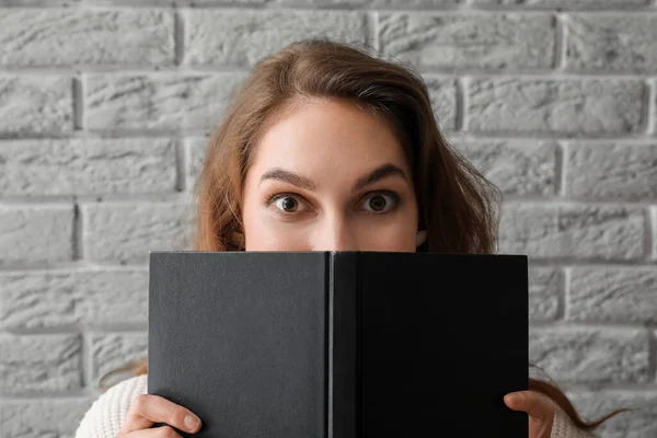 Νεαρή Γυναίκα Κρατώντας Άνοιξε Βιβλίο Κοντά Στον Τοίχο Γκρι Τούβλο — Φωτογραφία Αρχείου