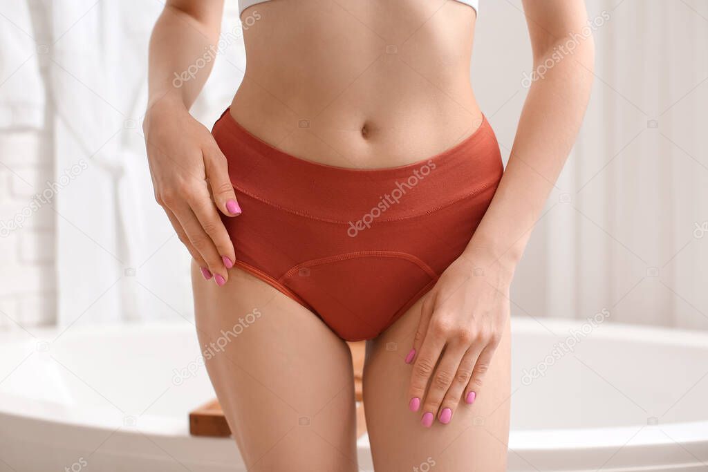 Young woman wearing red period panties in bathroom