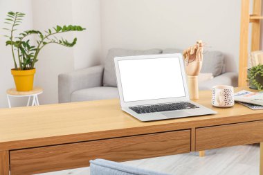 Modern dizüstü bilgisayarı, fincanı ve dergileri olan işyeri