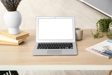 Modern laptop, books and magazine on table