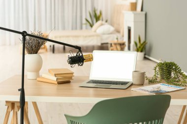 Modern dizüstü bilgisayarı ve profesyonel mikrofonu olan bir yayın evi.