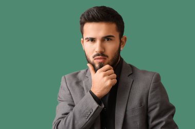 Yeşil arka planda dalgın sakallı adam