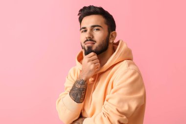 Pembe arka planda dalgın sakallı adam