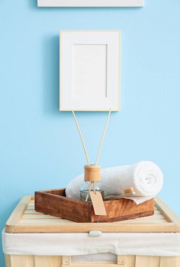 Sazlık ayırıcı ve havluyla mavi duvarın yanında durun.