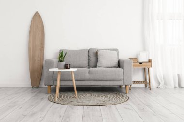 Kanepe, masa ve tahta sörf tahtasıyla aydınlık oturma odasının içinde.