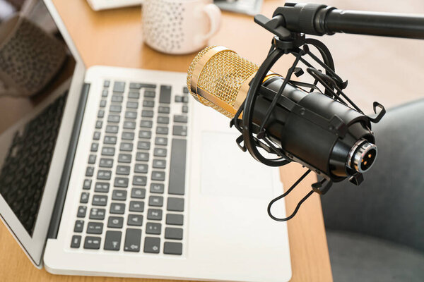 Professional microphone near modern workplace, closeup