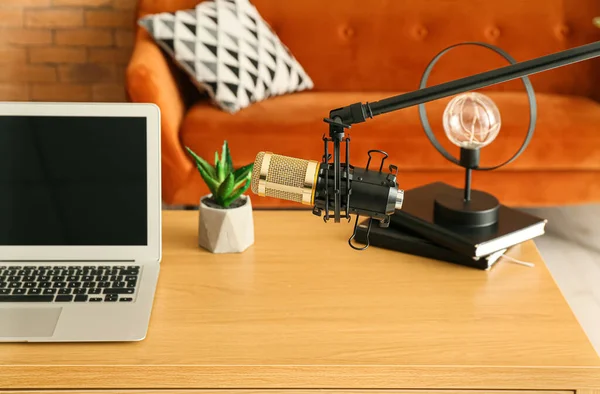 Stand with professional microphone near modern workplace in room