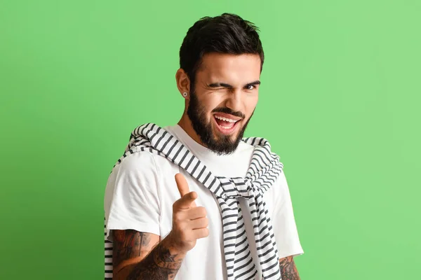 Young Bearded Man Pointing Viewer Winking Green Background — Stock Photo, Image