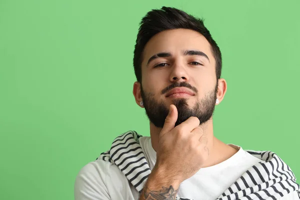 Joven Tocando Barba Sobre Fondo Verde — Foto de Stock