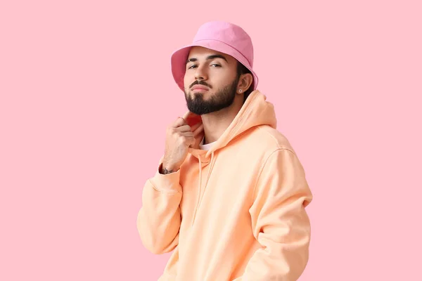 Fashionabla Skäggig Man Bär Huvtröja Och Hatt Rosa Bakgrund — Stockfoto