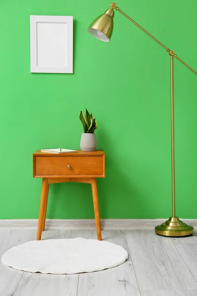 Wooden Table Houseplant Standard Lamp Green Wall — Stock Photo, Image
