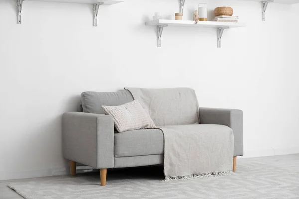Grey Sofa Pillows Plaid Shelves Hanging Light Wall — Stock Photo, Image