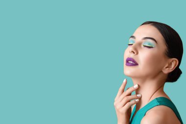 Beautiful young woman with stylish unusual makeup on color background with space for text