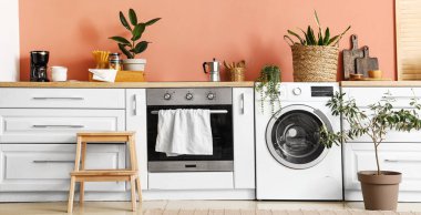 Modern çamaşır makinesi olan bir mutfak.