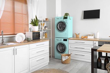 Işıl ışıl, iki çamaşır makinesi ve TV 'si olan modern mutfak.