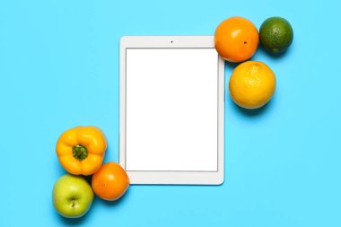 Mavi arka planda yeni ürünler ve tablet bilgisayar. Dünya Vegan Günü kavramı