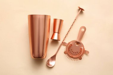 Bakır tart sallayıcı, çifte jigger, süzgeç ve renk arkaplanında karıştırma kaşığı