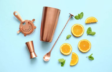 Mavi arka planda bakır barmen araçları ve malzemeler
