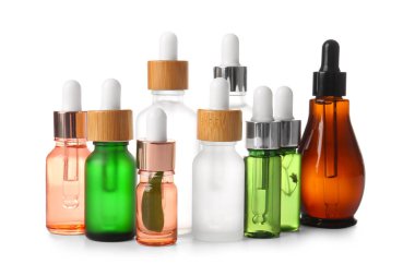 Beyaz arka planda bir sürü farklı serum şişesi var.