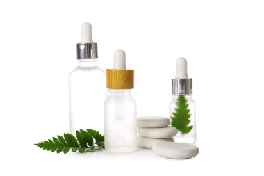 Beyaz arka planda doğal serum ve spa taşları.