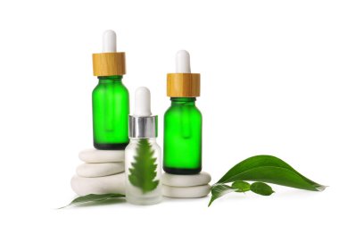 Beyaz arka planda doğal serum, spa taşları ve bitki yaprakları olan bileşim