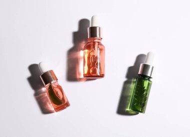 Beyaz arka planda farklı serum şişeleri