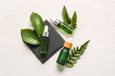 Işık arka planında doğal serum ve bitki yaprakları olan bileşim