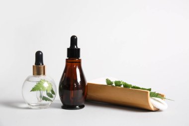 Beyaz arka planda iki şişe doğal serum.