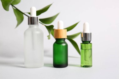Beyaz arka planda doğal serum şişeleri