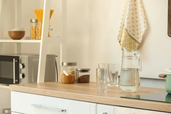 Kendi Dengan Air Dan Gelas Kosong Meja Dapur Ringan — Stok Foto