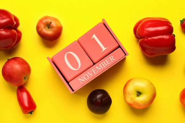 日付とキューブカレンダー11月1日 黄色の背景に新鮮な果物や野菜 クローズアップ 世界ビーガン日のコンセプト — ストック写真