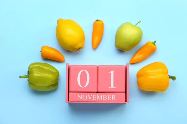 日付とキューブカレンダー11月1日 色の背景に異なる果物や野菜 世界ビーガン日のコンセプト — ストック写真