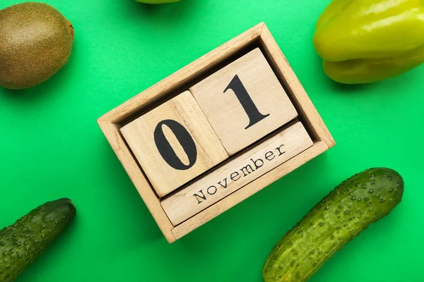 日付木製のキューブカレンダー11月1日 緑の背景に野菜や果物 クローズアップ 世界ビーガン日のコンセプト — ストック写真