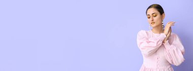 Leylak arka planında parlak makyajlı çekici genç bir kadın.