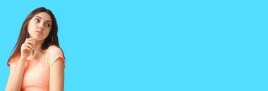 Açık mavi arkaplanda parlak makyajlı, metin için yeri olan güzel genç bir kadın.