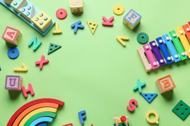 Yeşil arka planda eğitici oyuncaklardan yapılmış çerçeve