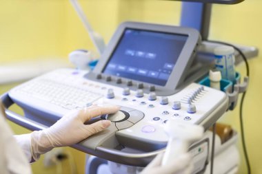 Klinikte ultrason cihazı kullanan bir doktor.