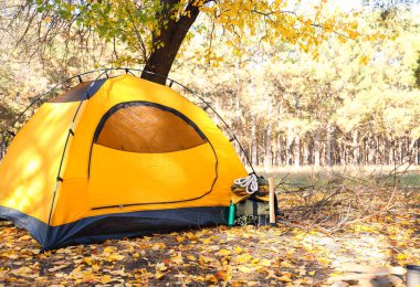 Ormandaki çadırın yakınındaki hayatta kalma çantasıyla turistin sırt çantası.