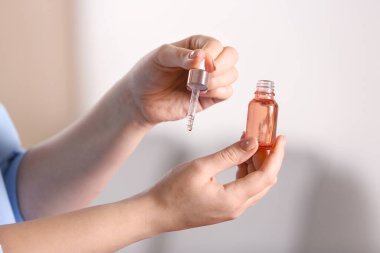 Kadın eline serum sürüyor, yakın plan.