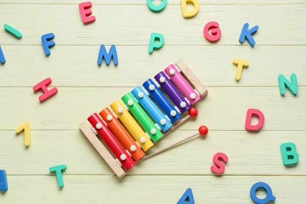 Xylophon Spielzeug Und Buchstaben Auf Gelbem Holzgrund — Stockfoto