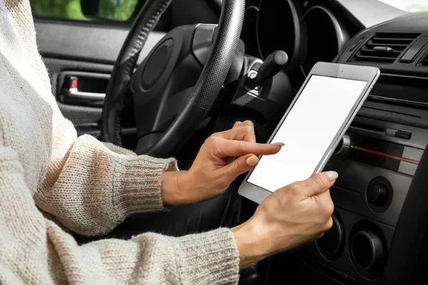 Female driver using tablet computer for navigation