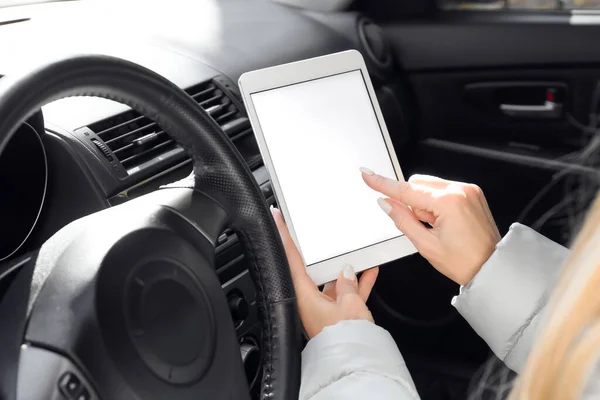 Female driver using tablet computer for navigation, closeup