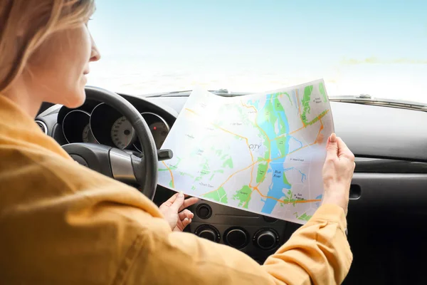 Female driver with city map in car