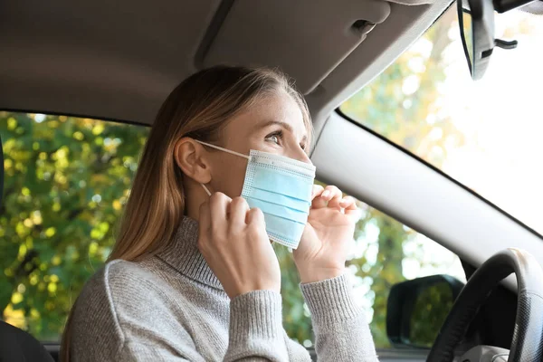 Motorista Feminina Colocando Máscara Médica Carro — Fotografia de Stock