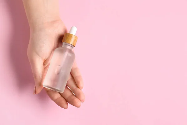 Mano Femenina Con Botella Suero Sobre Fondo Rosa Primer Plano — Foto de Stock