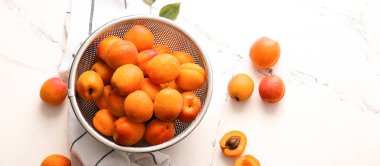 Hafif arka planda lezzetli olgun kayısılara sahip Colander, üst görünüm