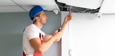 Teknisyen odaya akıllı ev güvenlik sistemi kuruyor